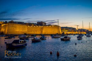 birgu malta walls fortification citadel lit dusk boats harbor bay